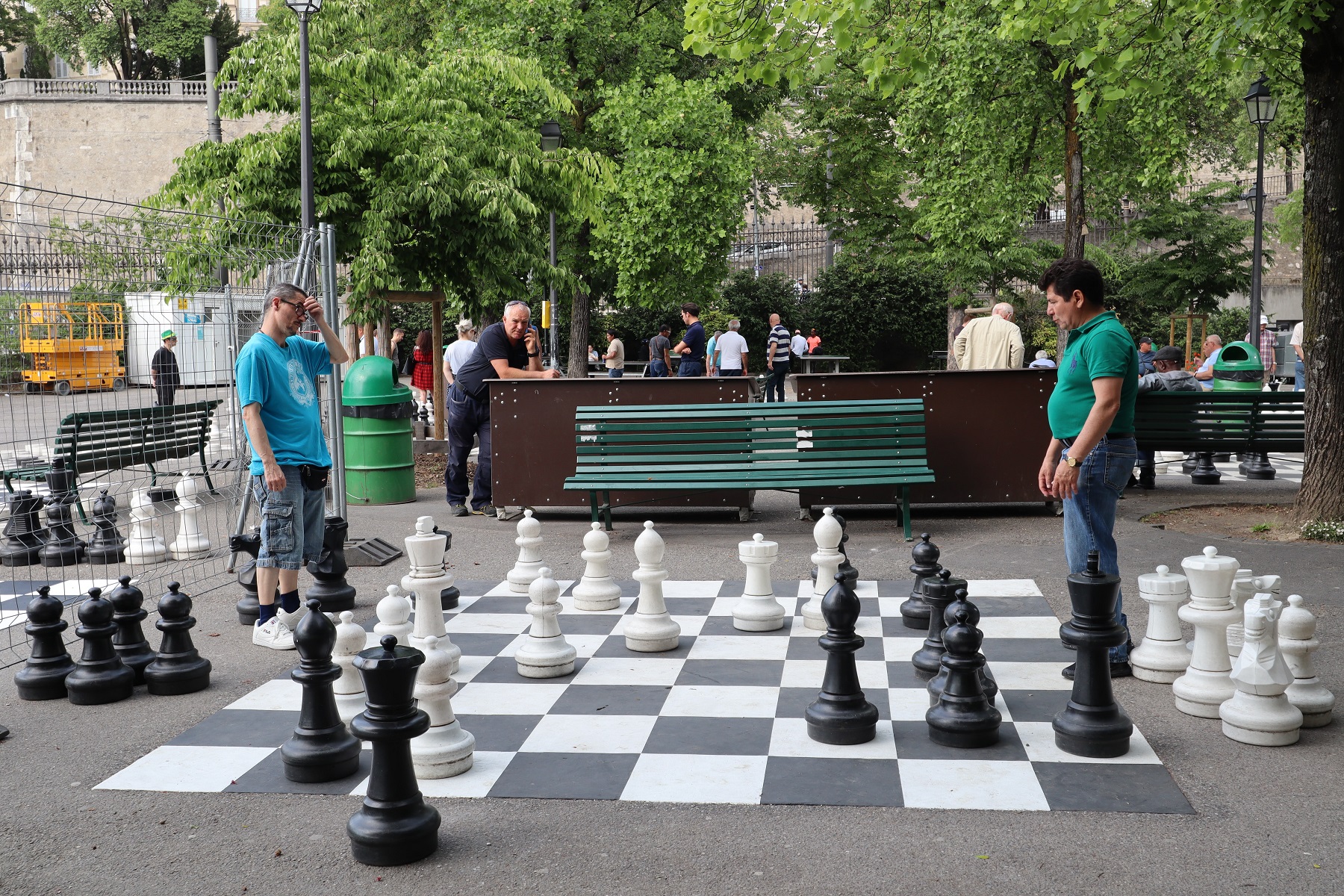 Two men playing giagant chess in a park